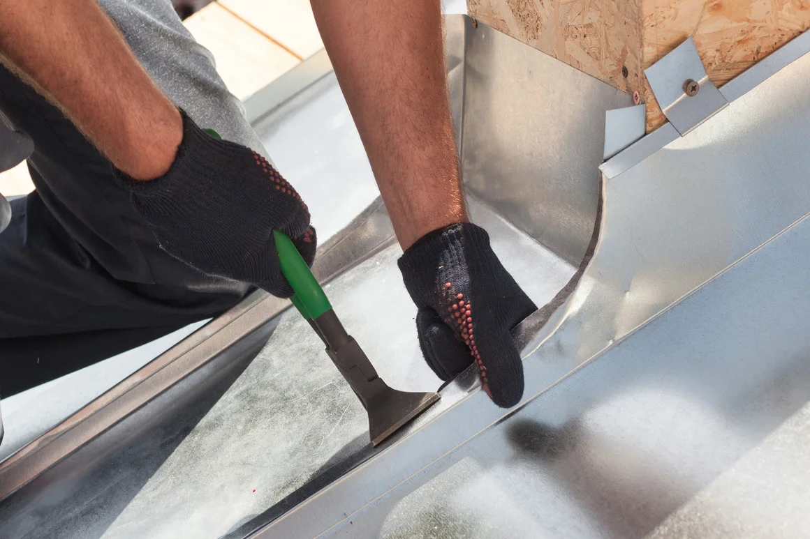 Handwerker biegt Blech mit Zange